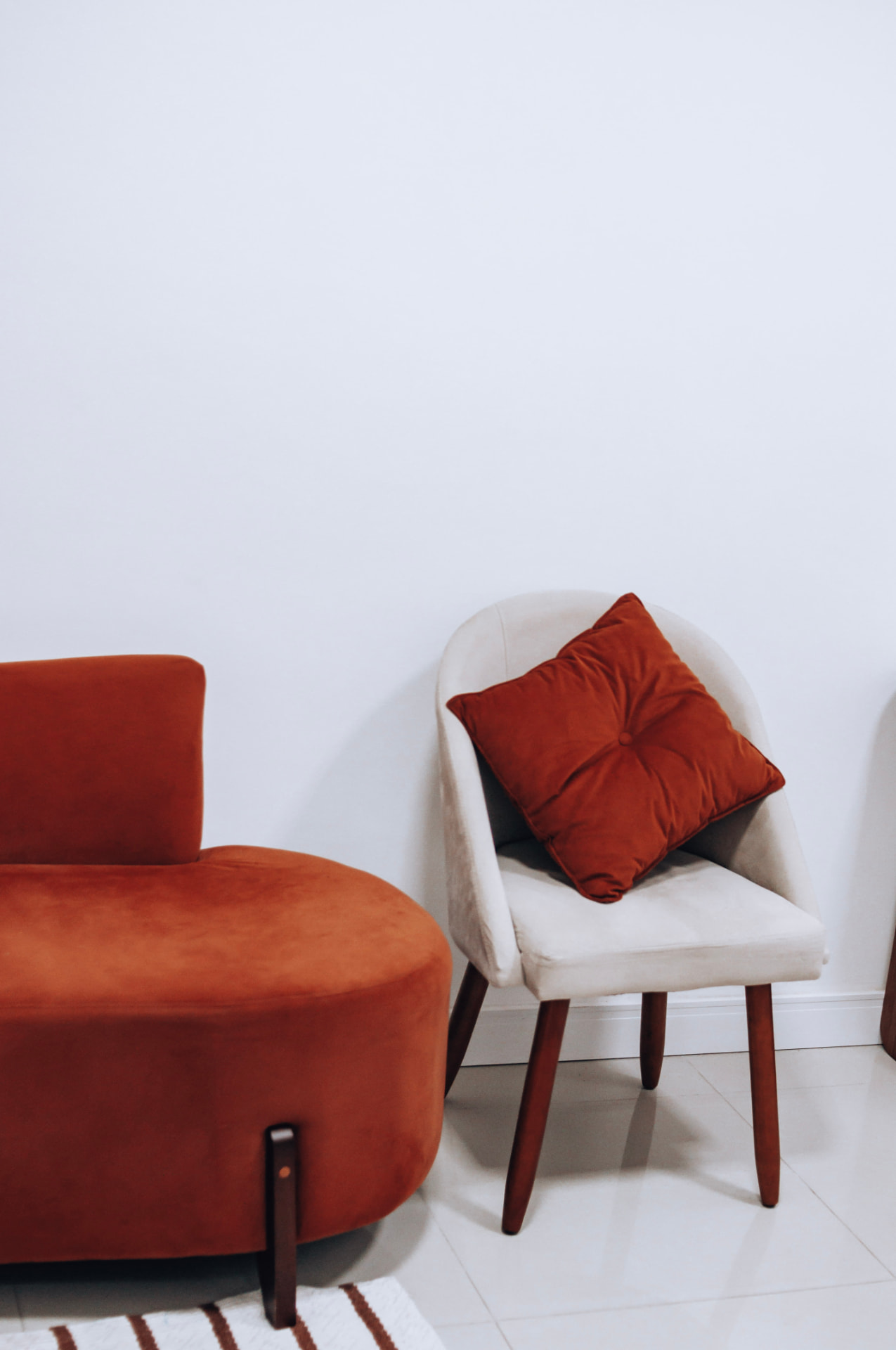 Poltronas em tom terracota na sala de espera do consultório